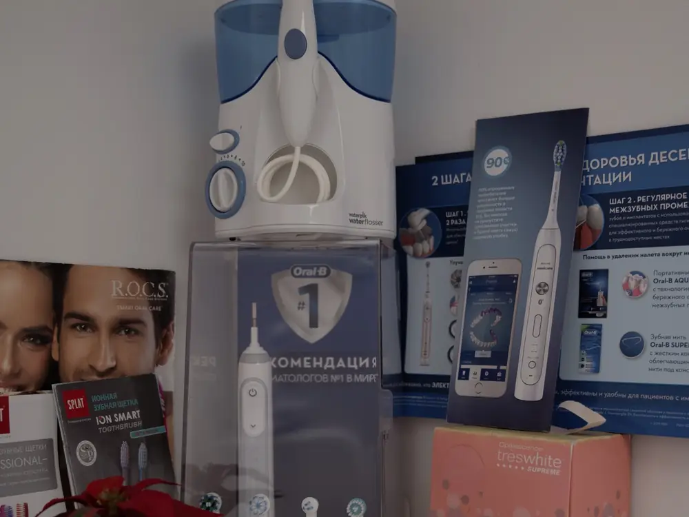 Стенд с электрическими зубными щётками и ирригаторами Oral-B и Waterpik в клинике